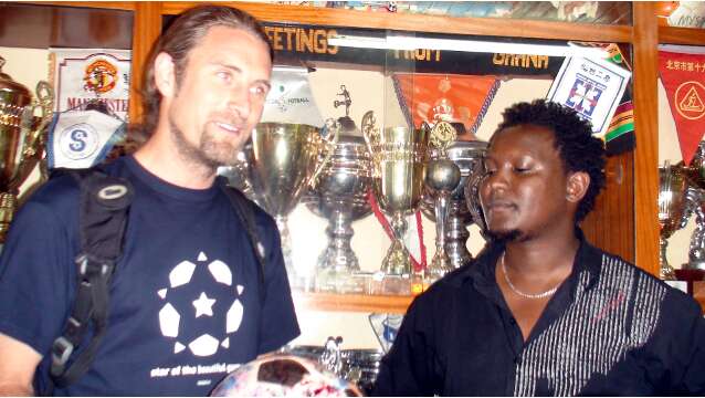 John Ndichu Ng'ethe and Andrew in front of MYSA's trophy cabinet