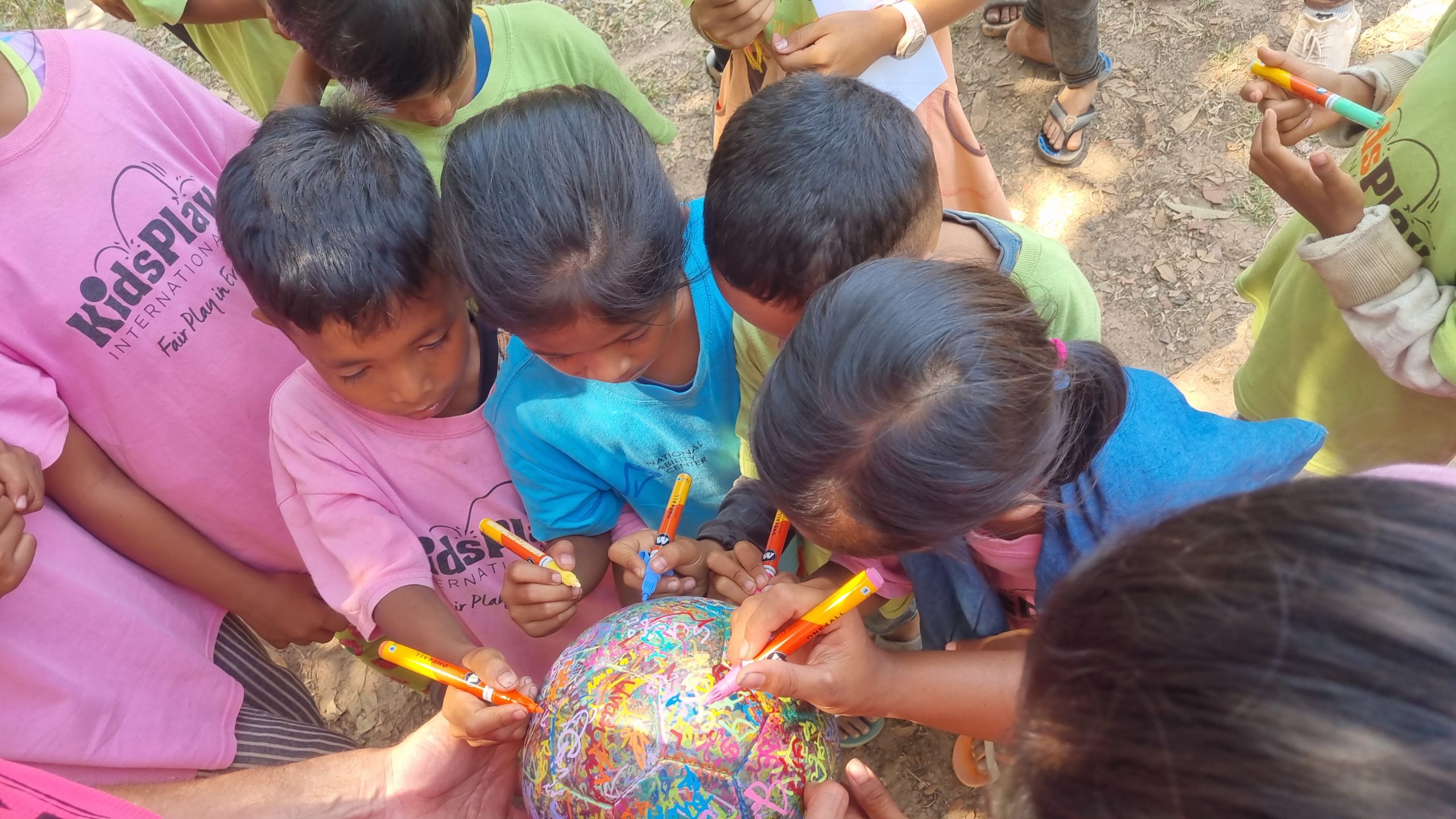 Children sign The Ball at Kids Play International, Cambodia