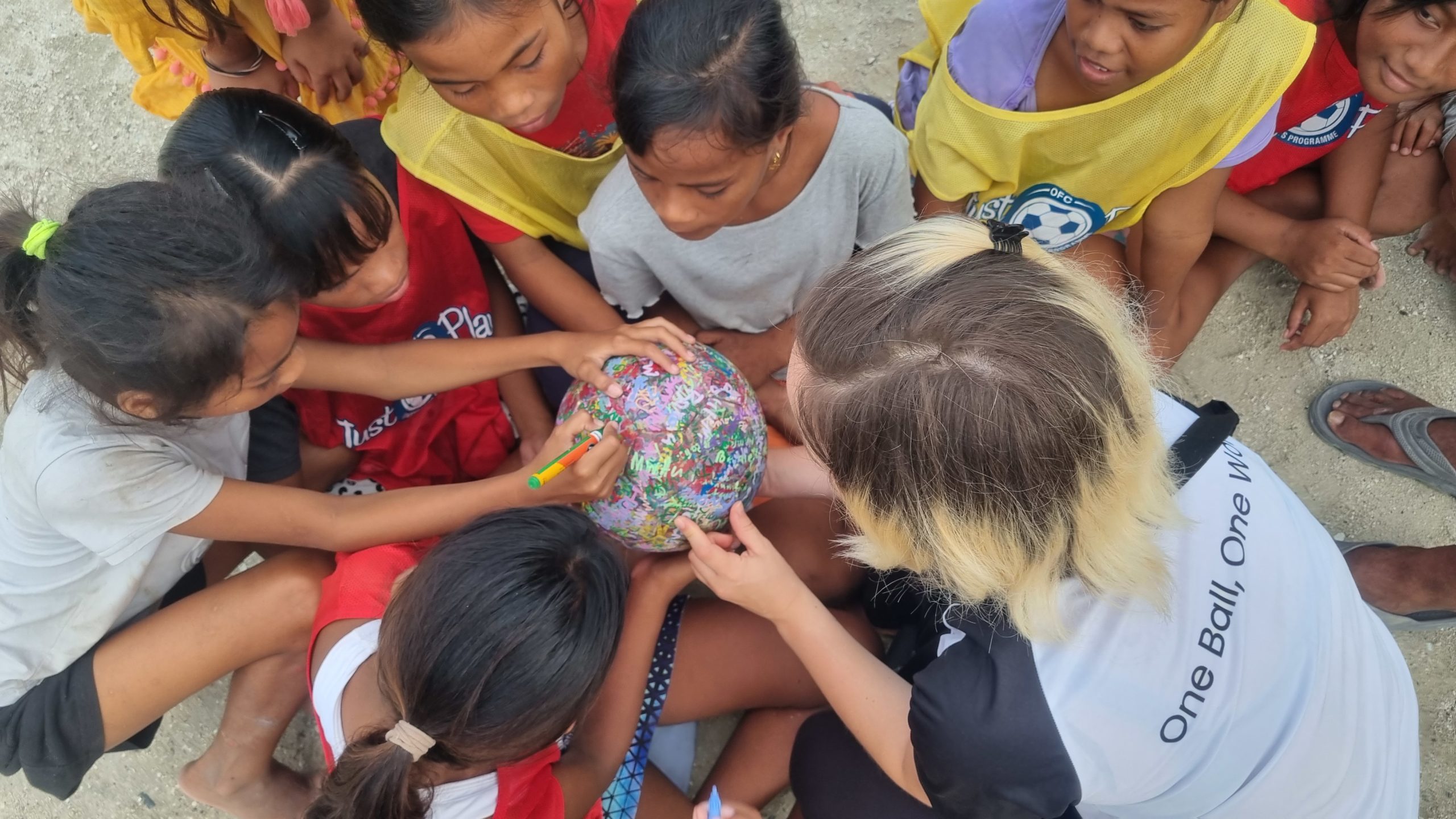 Kids from the OFC Just Play Program in Kiribati sign The Ball (June 2023)