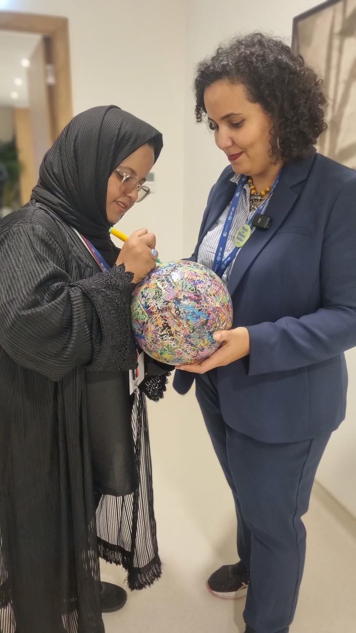 Nesmah Mansoor is holding The Ball for her friend to sign